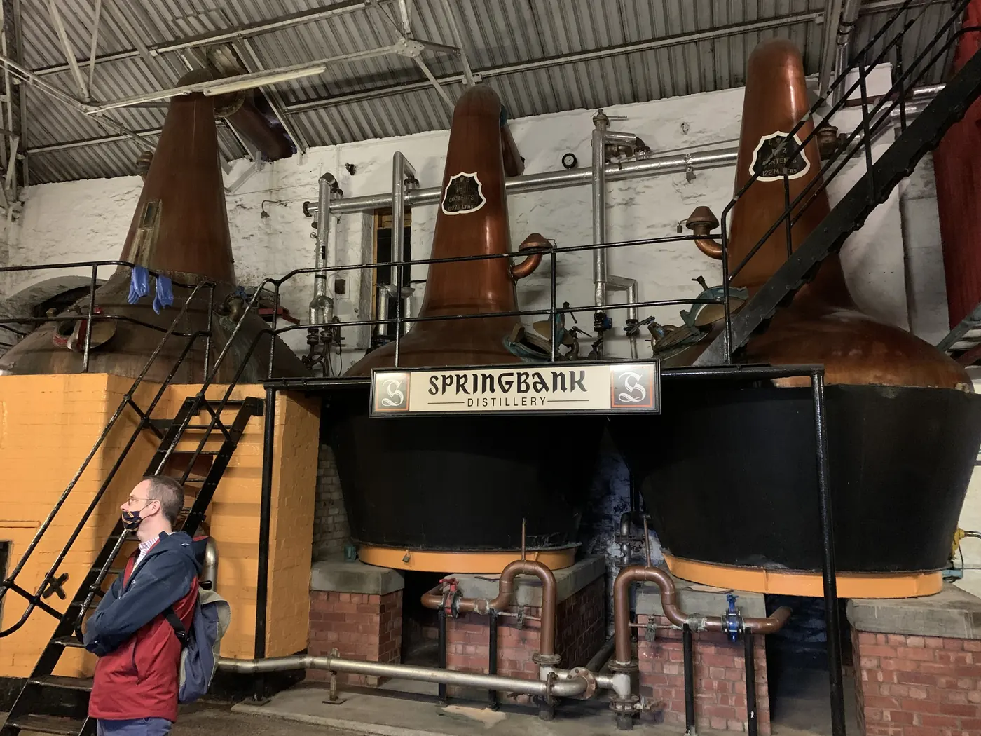 Ba nồi chưng cất đồng trong nhà máy Springbank ở Campbeltown, biển hiệu Springbank Distillery treo giữa hai nồi