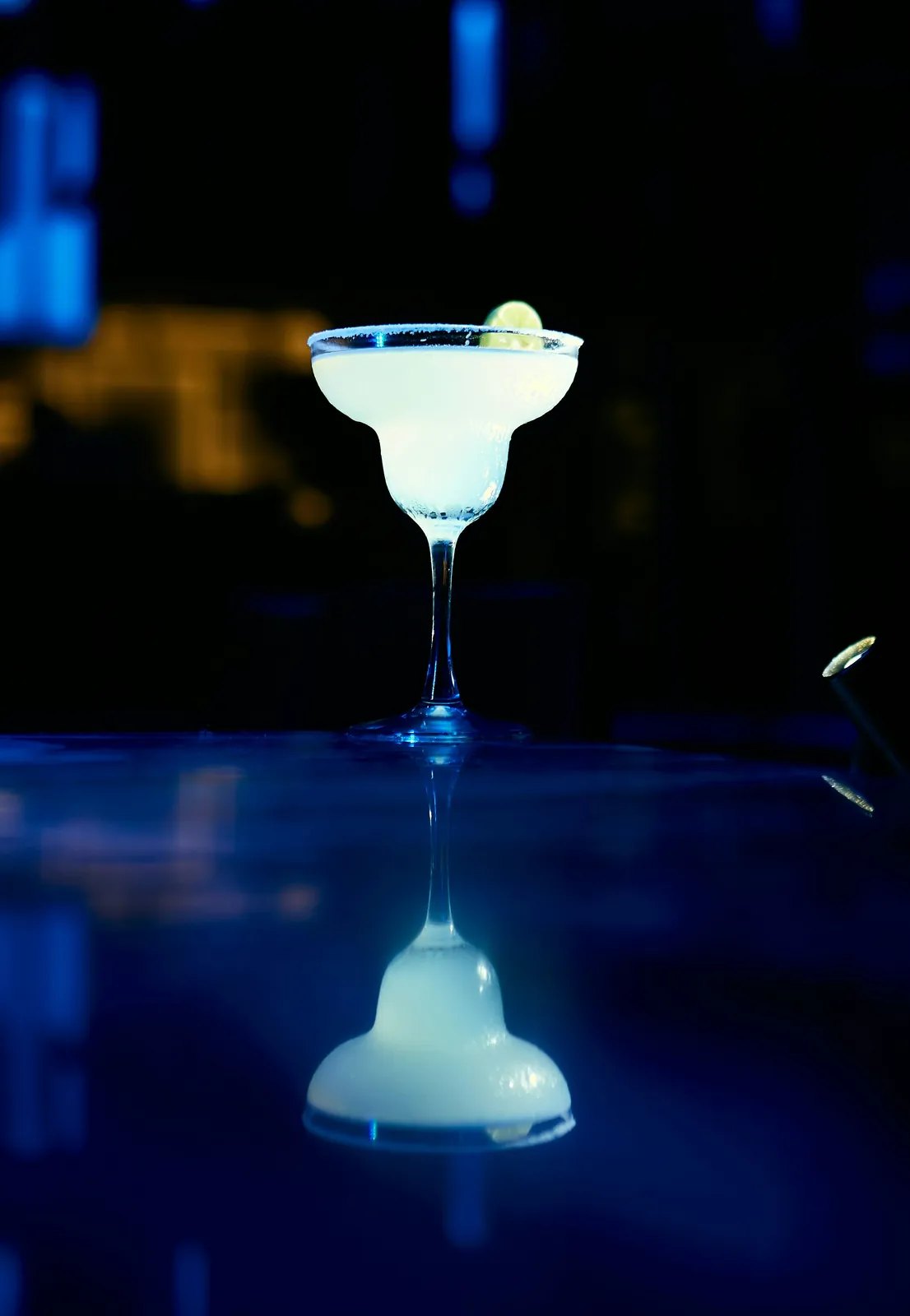 Ly Margarita viền muối với lát chanh trong quầy bar tối