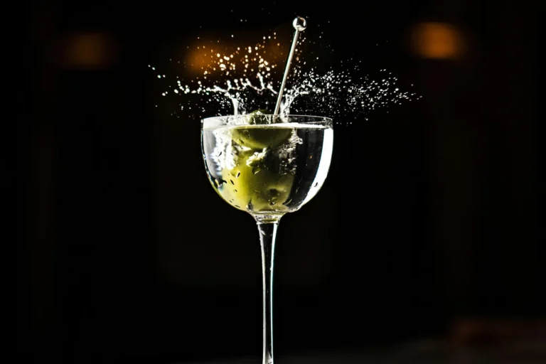 Ly Dry Martini với quả olive rơi vào làm rượu bắn tung toé