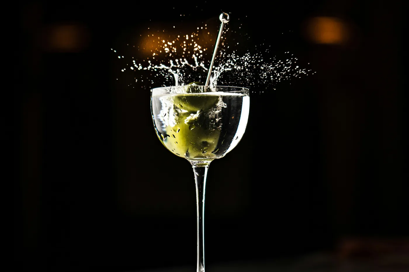 Ly Dry Martini với quả olive rơi vào làm rượu bắn tung toé